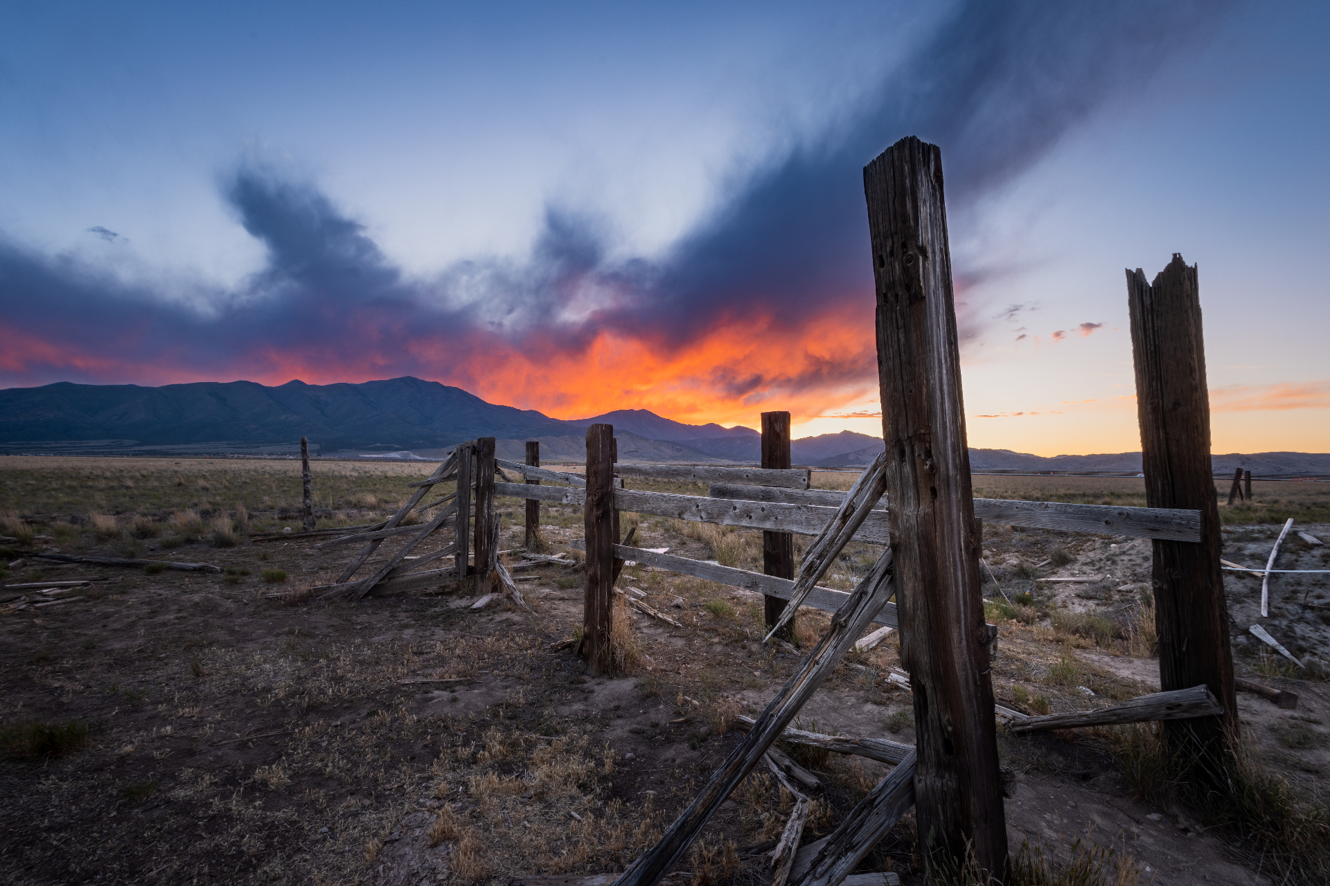 Old corral fencing with Eagle Mountain peaks and a vivid sunset